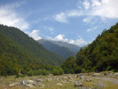 Údolí gruzínské řeky Kabali, vrcholky na obzoru dosahují asi 2 900 m n. m. V kamenité nivě se střídají olšiny  a kravské pastviny. Foto P. Novák